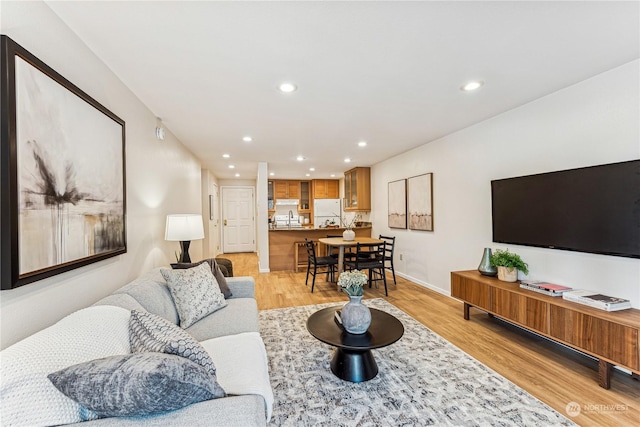 living room featuring sink and light hardwood / wood-style flooring