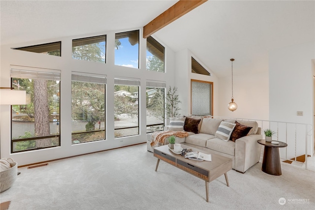 carpeted living room with beamed ceiling, plenty of natural light, and high vaulted ceiling