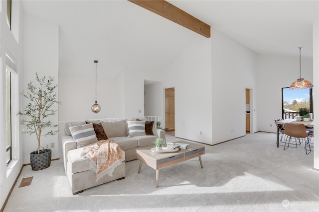 living room with high vaulted ceiling, beam ceiling, and light colored carpet