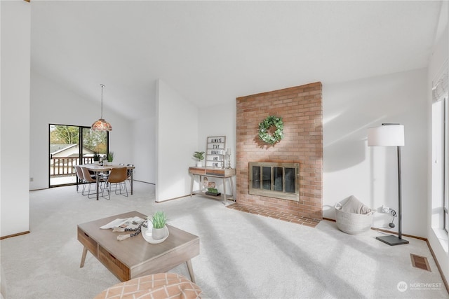 carpeted living room with a brick fireplace and high vaulted ceiling