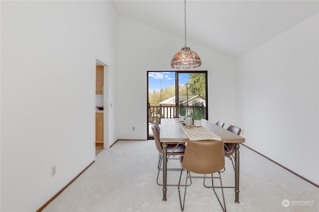 carpeted dining room with high vaulted ceiling