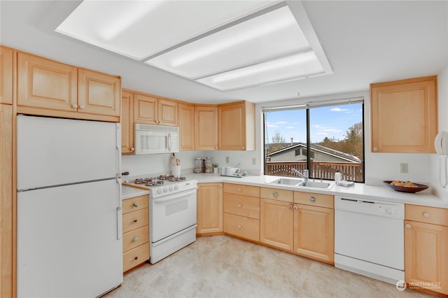 kitchen with light brown cabinetry, sink, and white appliances