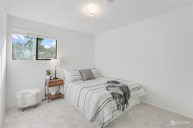 bedroom with light carpet and a textured ceiling