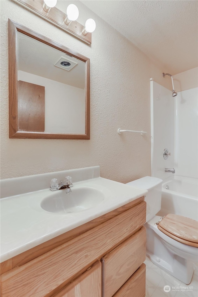 full bathroom featuring washtub / shower combination, vanity, toilet, and a textured ceiling