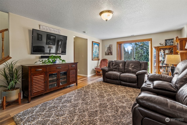 living room featuring a textured ceiling and light wood-type flooring