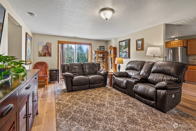 living room featuring a textured ceiling and light wood-type flooring