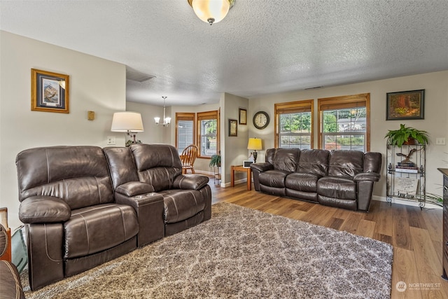 living room featuring hardwood / wood-style flooring, a chandelier, and a textured ceiling