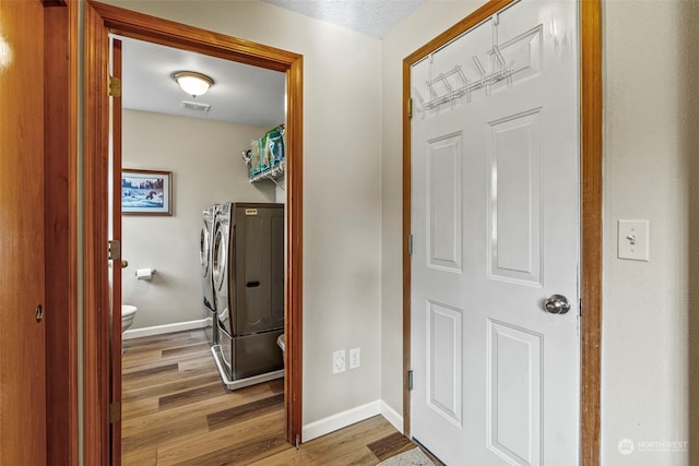 entrance foyer with separate washer and dryer and hardwood / wood-style floors