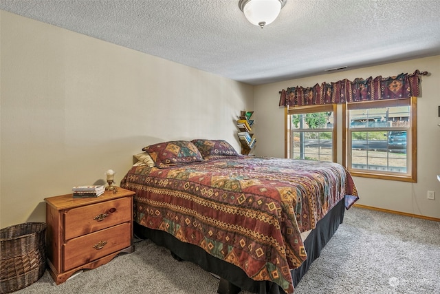 bedroom featuring light colored carpet and a textured ceiling