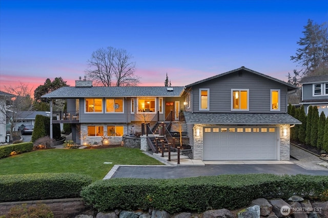 view of front of property with aphalt driveway, a garage, stone siding, a yard, and a chimney