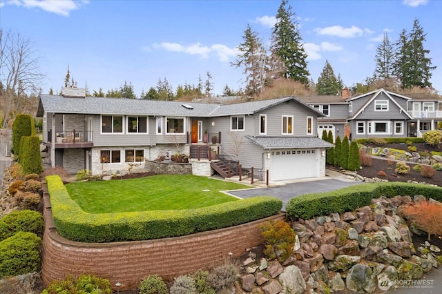 view of front of home with a chimney, aphalt driveway, a front lawn, and an attached garage