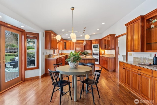 dining room with baseboards, wood finished floors, and recessed lighting