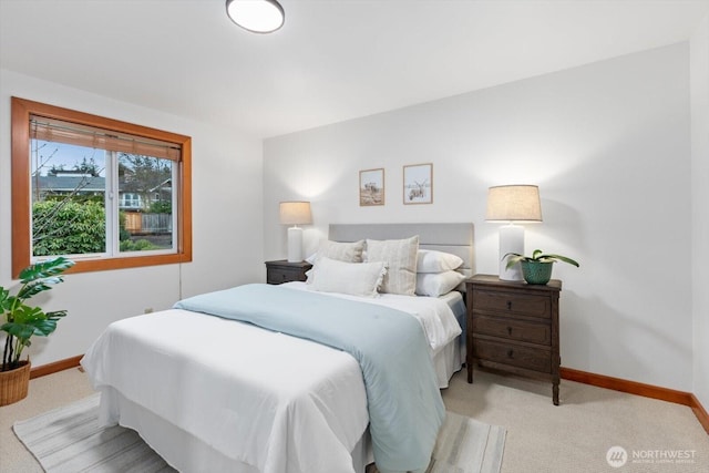 bedroom with baseboards and light colored carpet