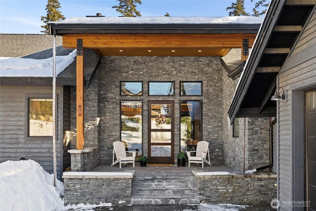 snow covered property entrance featuring covered porch