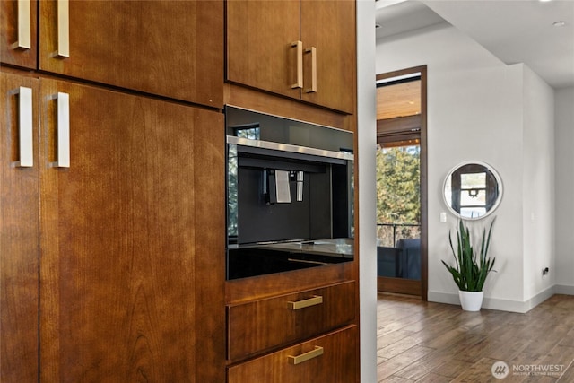 kitchen with dark wood-type flooring and black oven