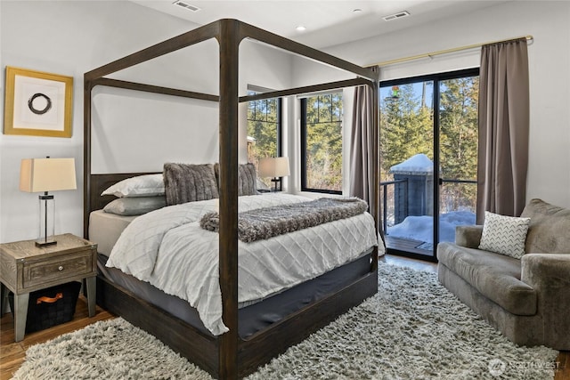 bedroom featuring wood-type flooring and access to outside