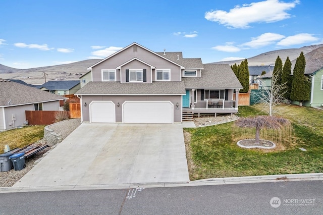 view of front of home featuring a garage, a mountain view, a porch, and a front yard