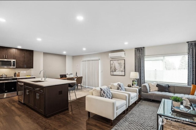 living room featuring dark wood-type flooring, sink, and a wall unit AC