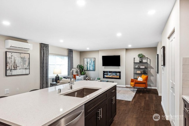 kitchen with sink, dishwasher, dark hardwood / wood-style floors, a wall mounted AC, and an island with sink