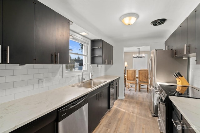 kitchen featuring electric stove, sink, pendant lighting, tasteful backsplash, and stainless steel dishwasher