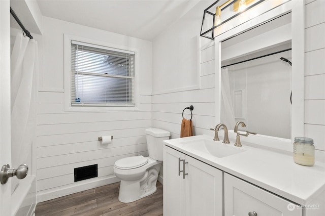 bathroom with hardwood / wood-style flooring, vanity, toilet, and curtained shower