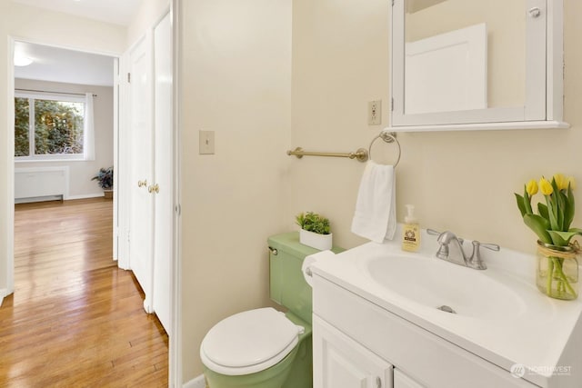 bathroom featuring hardwood / wood-style flooring, toilet, and vanity