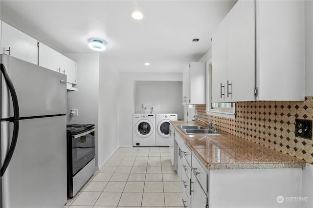 kitchen featuring white cabinetry, appliances with stainless steel finishes, sink, and independent washer and dryer