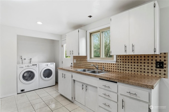 laundry area featuring washer and dryer, light tile patterned flooring, sink, and cabinets