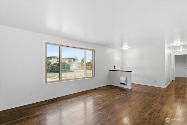 unfurnished living room with dark wood-type flooring