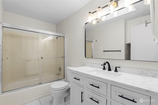 full bathroom with tile patterned flooring, vanity, combined bath / shower with glass door, and toilet