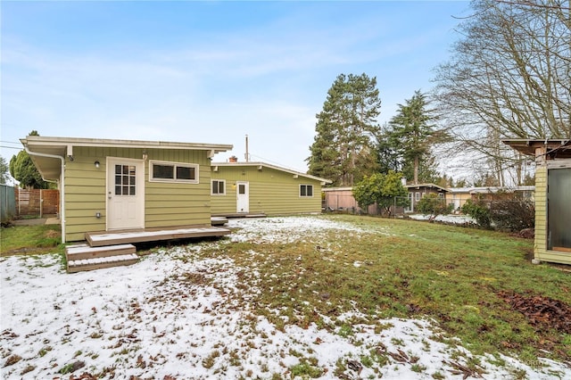 snow covered house with an outbuilding and a lawn