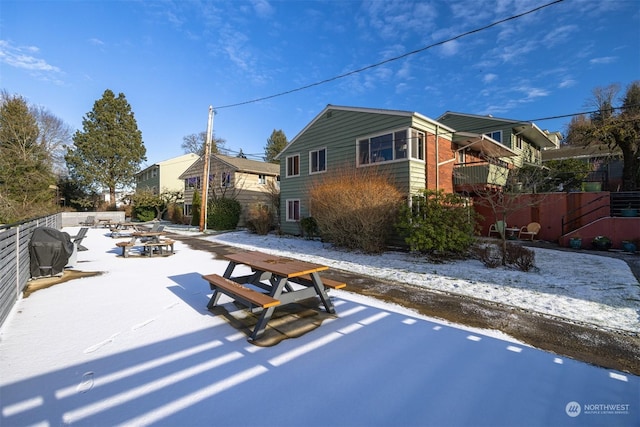 view of snow covered back of property