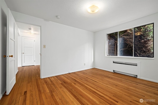 spare room featuring hardwood / wood-style flooring and a textured ceiling