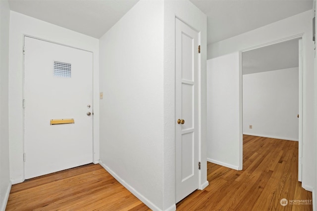 hallway with hardwood / wood-style floors