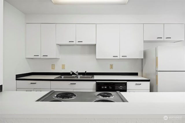 kitchen featuring white refrigerator, dishwasher, sink, and white cabinets