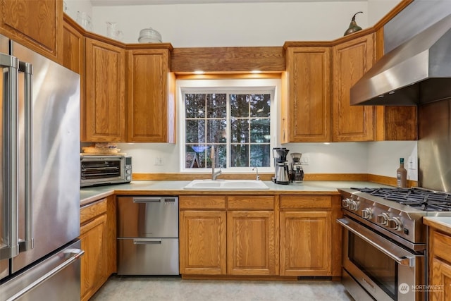 kitchen featuring high end appliances, sink, and extractor fan