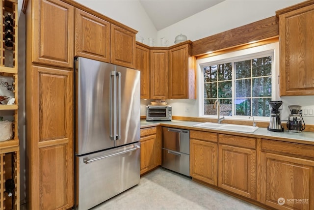 kitchen featuring sink, vaulted ceiling, and appliances with stainless steel finishes