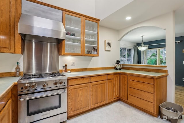 kitchen with hanging light fixtures, stainless steel stove, and ventilation hood