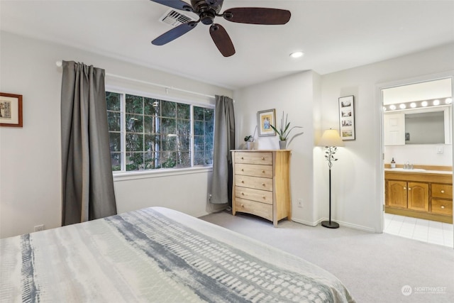 carpeted bedroom with ceiling fan, sink, and ensuite bath