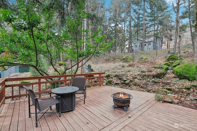 wooden terrace featuring an outdoor fire pit