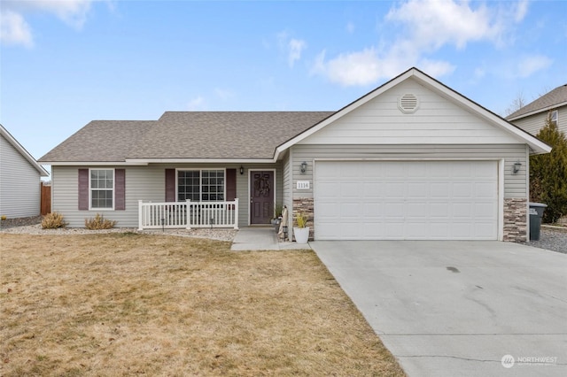 ranch-style house featuring a garage, covered porch, and a front yard