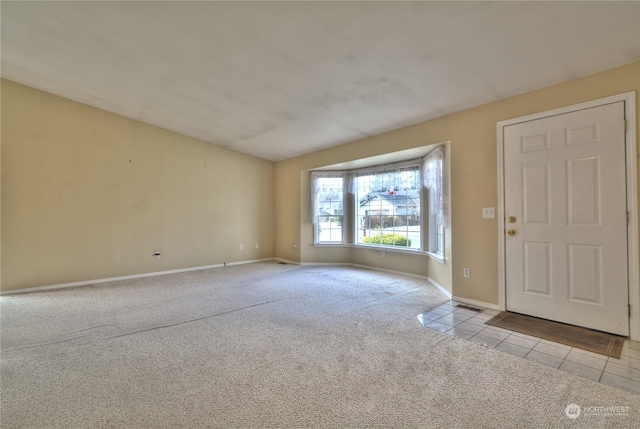 carpeted foyer entrance featuring lofted ceiling