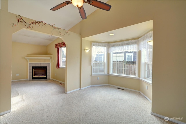 unfurnished living room with lofted ceiling, light carpet, a fireplace, and ceiling fan