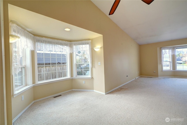 spare room featuring lofted ceiling, light colored carpet, and ceiling fan