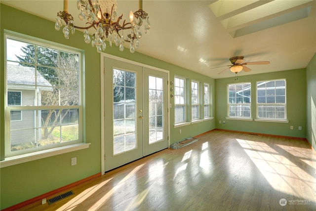 unfurnished sunroom featuring ceiling fan with notable chandelier and french doors