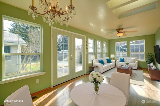 sunroom with french doors, a healthy amount of sunlight, and ceiling fan with notable chandelier