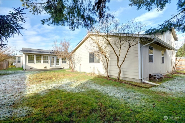 rear view of property featuring a lawn