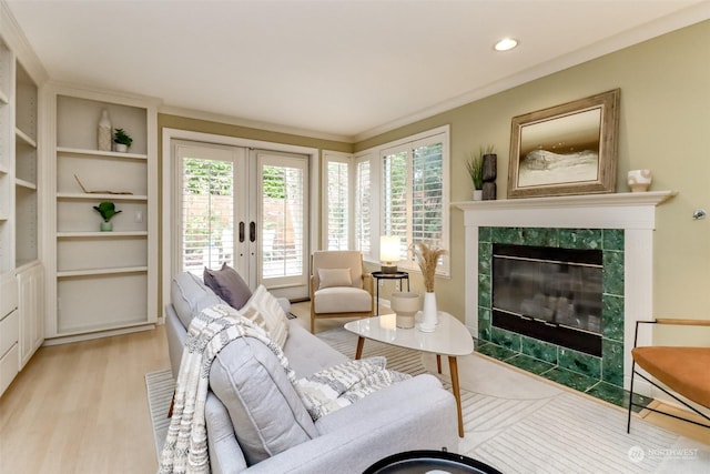 living room featuring a fireplace, light hardwood / wood-style floors, and french doors