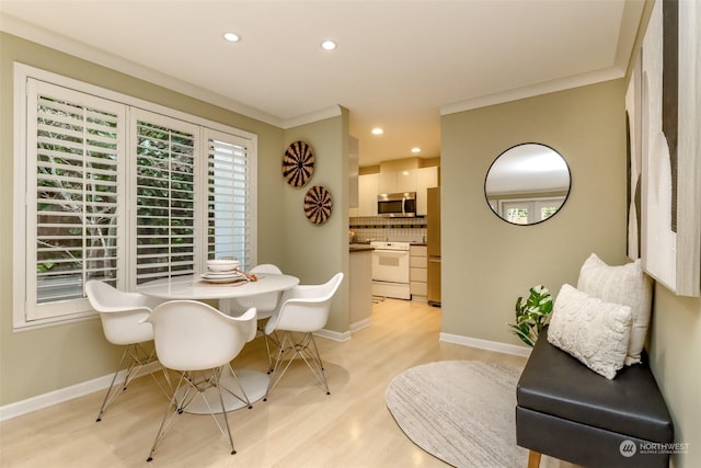 dining area with crown molding and light wood-type flooring