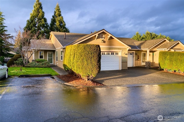 ranch-style home with a garage, driveway, and a front yard